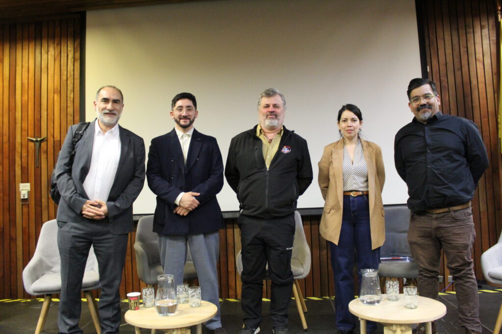 Fotografía de los invitados al conversatorio junto a Claudio Santander